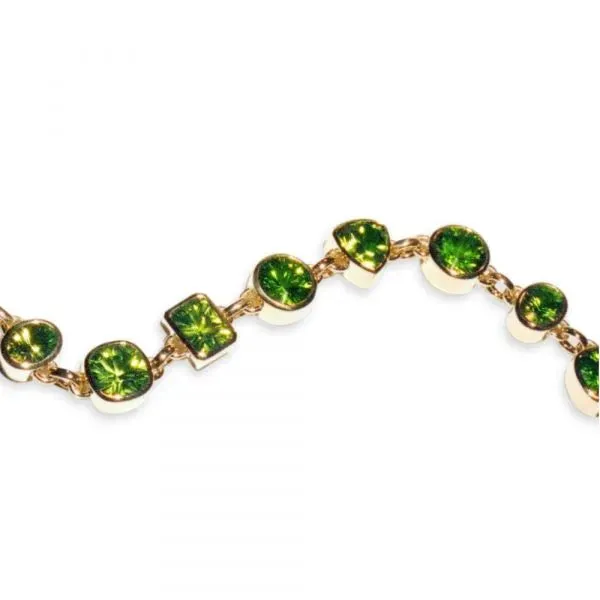 Yellow gold bracelet with bezel set peridot in multiple shapes